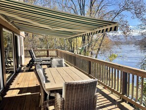 A wooden deck with a table and chairs, overlooking a lake. - Waterfront, Luxury Panoramic View, Fast Wi-Fi, Private River Access Steps Away! (Luray)