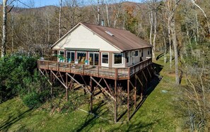 A two-story house with a deck, surrounded by trees and a grassy area. - Waterfront, Luxury Panoramic View, Fast Wi-Fi, Private River Access Steps Away! (Luray)