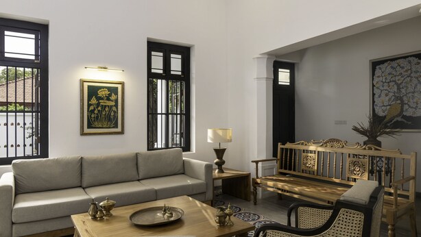 A living room with a sofa, a wooden coffee table, a bench, and a lamp.