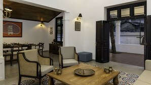 A room with a dining area, a sofa, and a coffee table with decorative items.