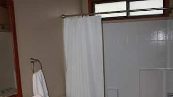 A bathroom with a toilet, sink, and shower curtain.