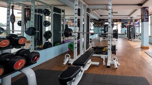 Ein Fitnessstudio mit Gewichte, Bänken und Spiegeln.
