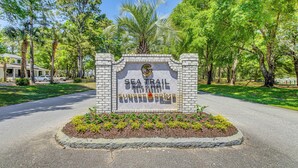 A sign for Sea Trail Golf Resort with a brick border and a palm tree in the center. - Golf Villa Near Sunset Beach & Intracoastal! (Sunset Beach)