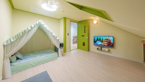 Habitación infantil con literas, un televisor y una puerta que da a otra habitación.