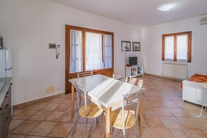 Un grand espace de vie comprenant une table à manger, des chaises, un canapé et un téléviseur.