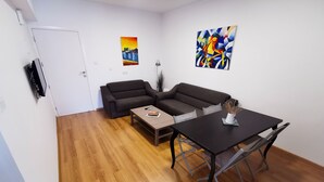 Uma sala de estar moderna com um sofá, uma mesa de centro e uma mesa de jantar.