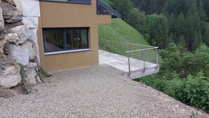 A modern building with a concrete deck and a metal railing overlooking a forested hillside. - New opening June 2022 - Chalet tree house with private whirlpool (Vandoies)