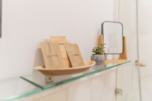 A glass shelf with three brown paper bags labeled "nature" and a small potted plant.