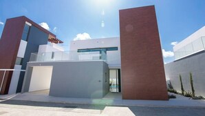 Un bâtiment moderne doté d’un toit plat, de grandes fenêtres et surplombant un ciel dégagé.