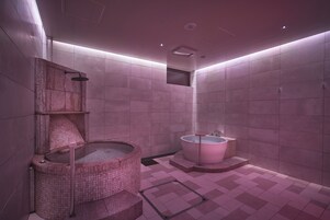 A modern bathroom with a large bathtub, a separate shower area, and a mosaic-tiled hot tub.