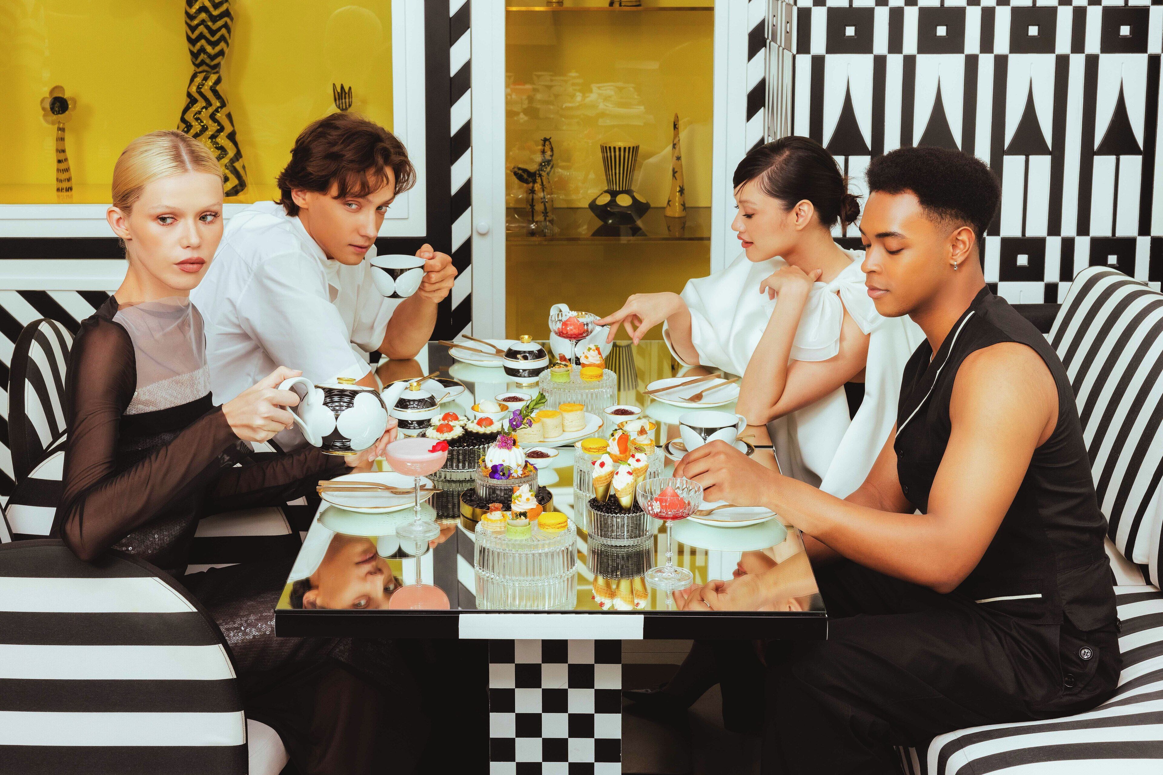 A group of people dining at a table with various desserts and drinks.
