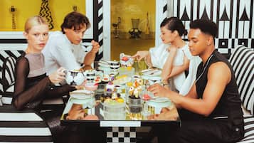A group of people dining at a table with various desserts and drinks.