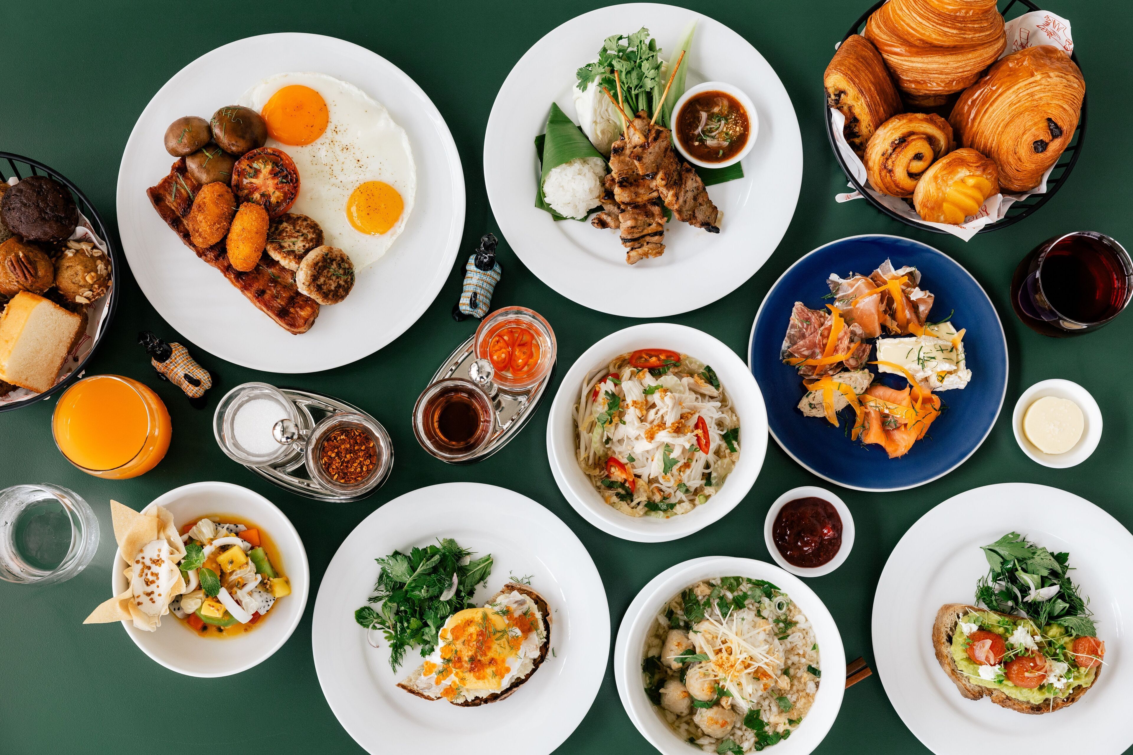A variety of dishes including eggs, meat, and pastries on a table.