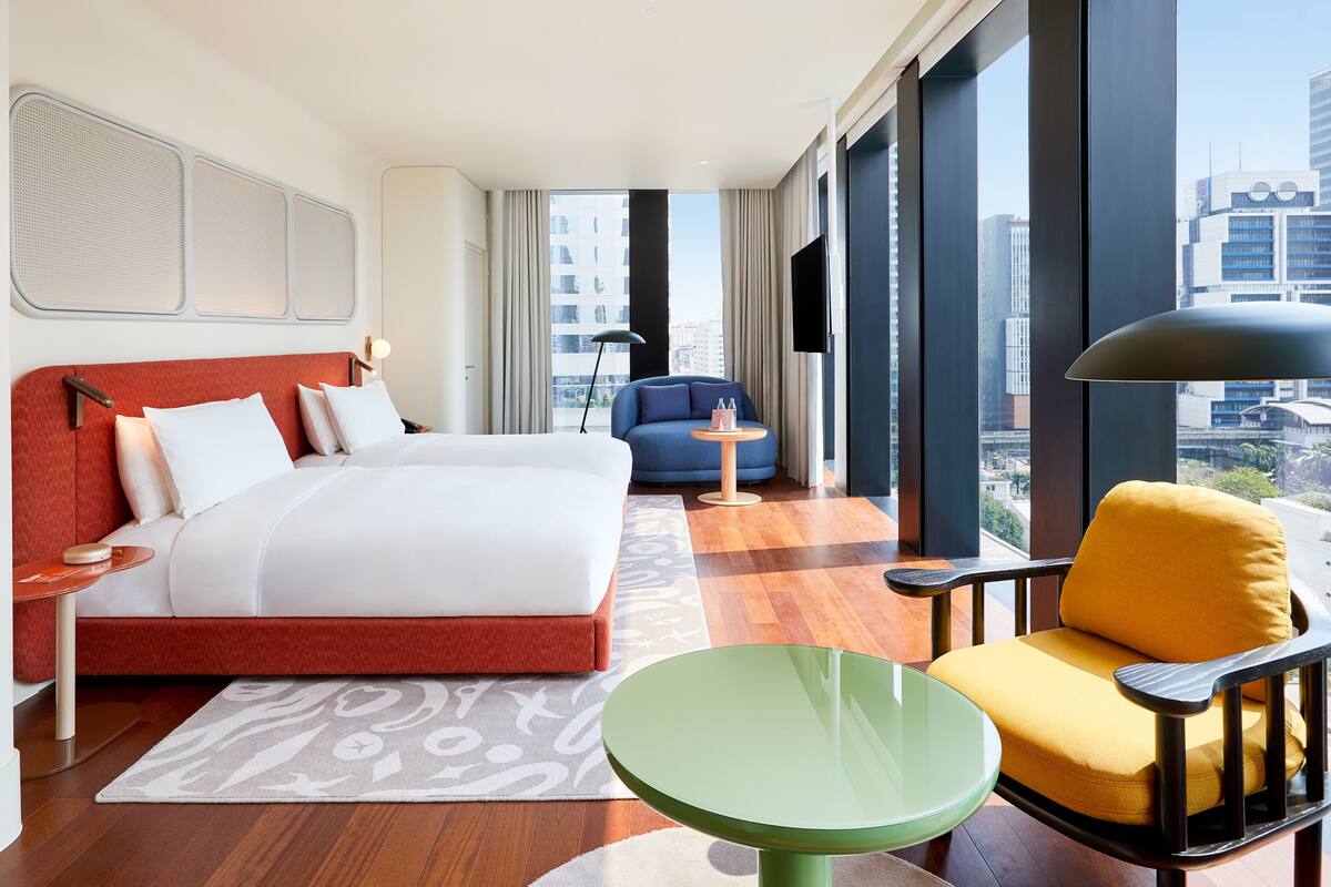 Ein Hotelzimmer mit einem Bett, einem Schlafsofa, einem kleinen Tisch und einem Sessel.