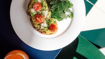 A plate with a sandwich and a side salad on a table.