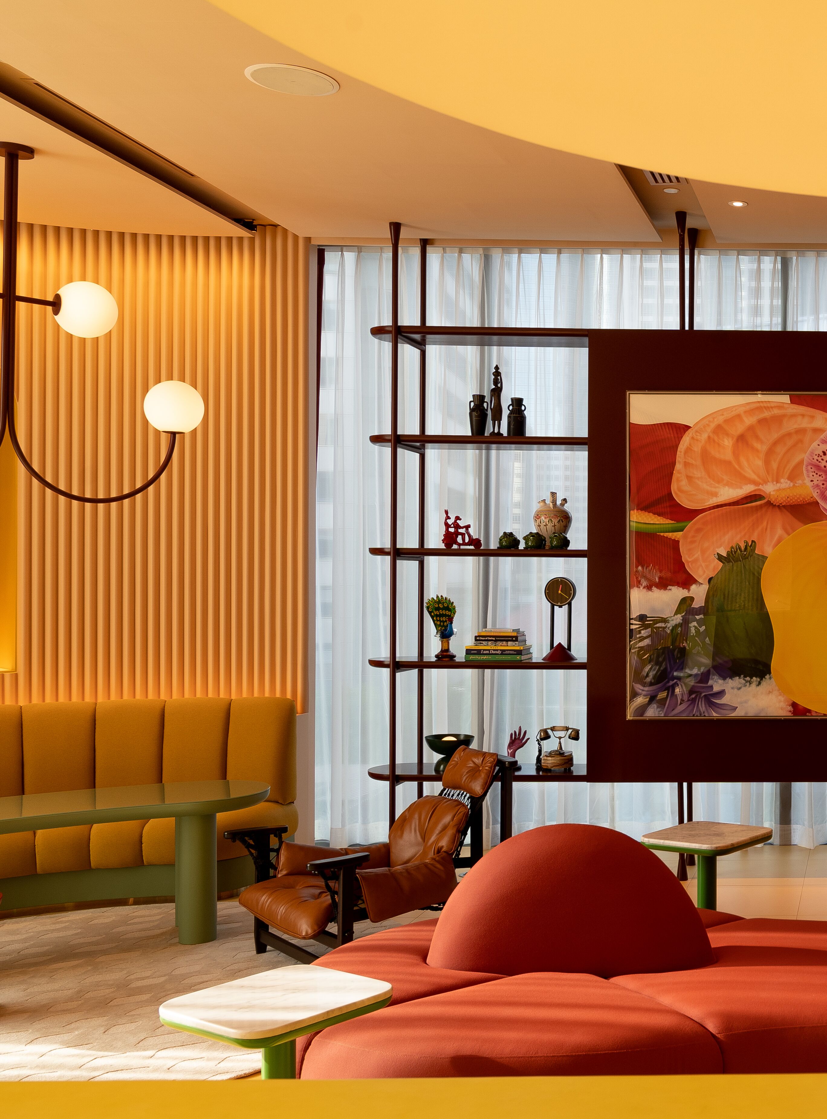 A modern living room with a sofa, a chair, a table, and a bookshelf.