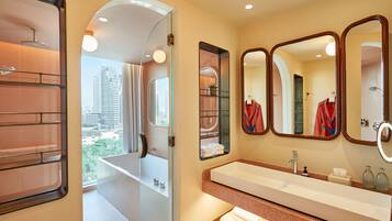 Une salle de bain moderne avec un grand miroir, une baignoire et une vue sur la ville.
