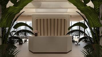 Een receptiebalie met een modern ontwerp, omringd door grote groene planten.