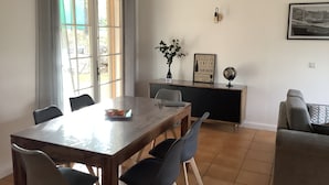 Een eetgedeelte met een houten tafel, vier stoelen, een wereldbol en een lijst met een citaat aan de muur.