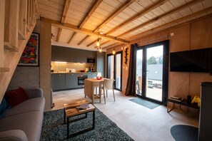 Een moderne woonruimte met keuken, eetgedeelte en een gezellige zithoek met bank en salontafel.