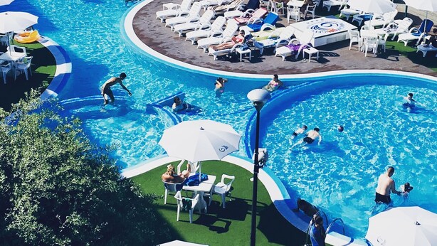 A large outdoor swimming pool with multiple lanes, sun loungers, and umbrellas. - Family Oasis Near the Sea (Lido di Spina)