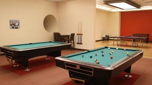 A pool table with balls, a second table, and a red wall. - Luxury Private Room in an Apartment Next to Barasti Beach  (Dubai)