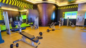 A gym with various exercise equipment, including a bench, dumbbells, and weight machines. - Luxury Private Room in an Apartment Next to Barasti Beach  (Dubai)