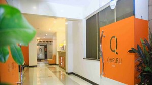 A hotel corridor with an orange wall featuring the hotel name 'QARIBU INN'. - Qaribu Inn Boutique Hotel Nairobi (Nairobi)