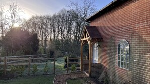 A brick building with a wooden porch and a window.