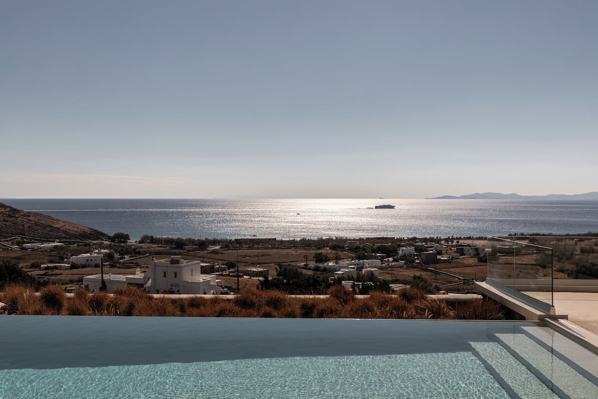 Una piscina con vistas claras al mar y edificios lejanos.