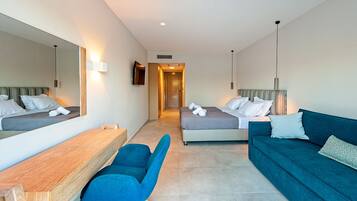 A hotel room with two beds, a desk, a chair, and a sofa.