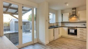 A modern kitchen with a sliding glass door leading to an outdoor patio.