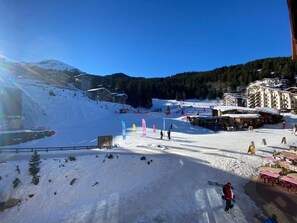 A ski resort with a snow-covered slope, ski lifts, and buildings in the background. - Spacious apartment 5 pax, south-facing balcony, parking included (La Tania)