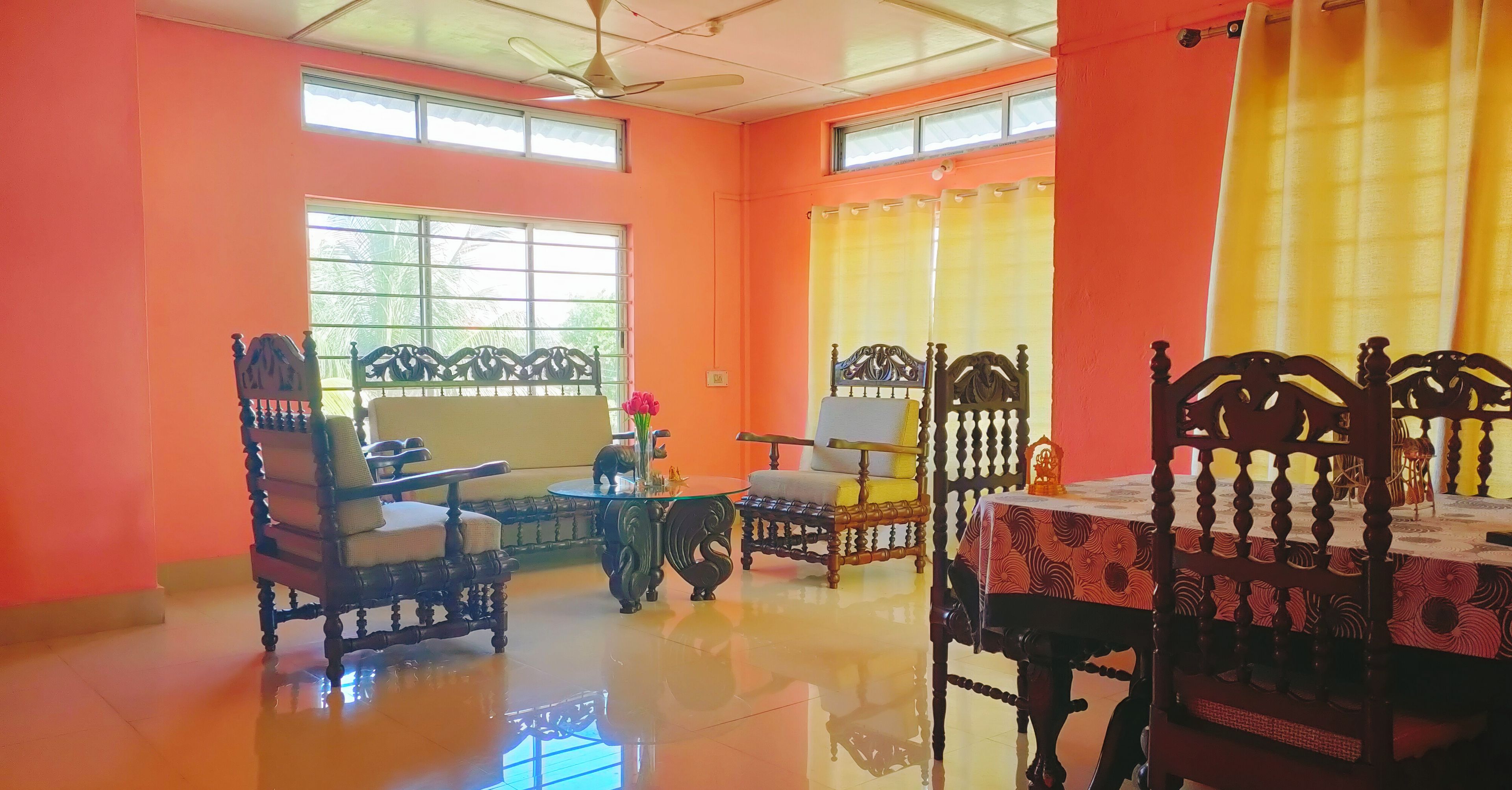 A spacious room with a high ceiling, large windows, and a polished floor.