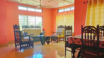 A spacious room with a high ceiling, large windows, and a polished floor.