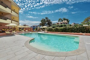 季节性开放的室外游泳池,池畔遮阳伞,日光浴躺椅