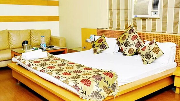 Ein Hotelzimmer mit Bett, Nachttisch, Sofa und Klimaanlage.