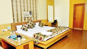 Ein Hotelzimmer mit einem Bett, einem Schreibtisch, einem Stuhl, einem Spiegel und einer Tür.