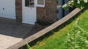 A house with a stone facade, a white garage door, and a small window.