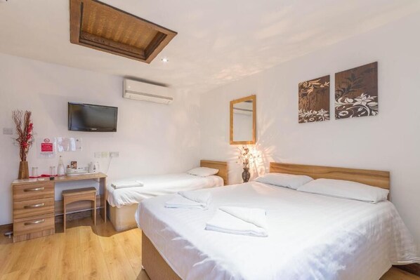 Habitación triple económica | Escritorio, tabla de planchar con plancha, wifi gratis y ropa de cama