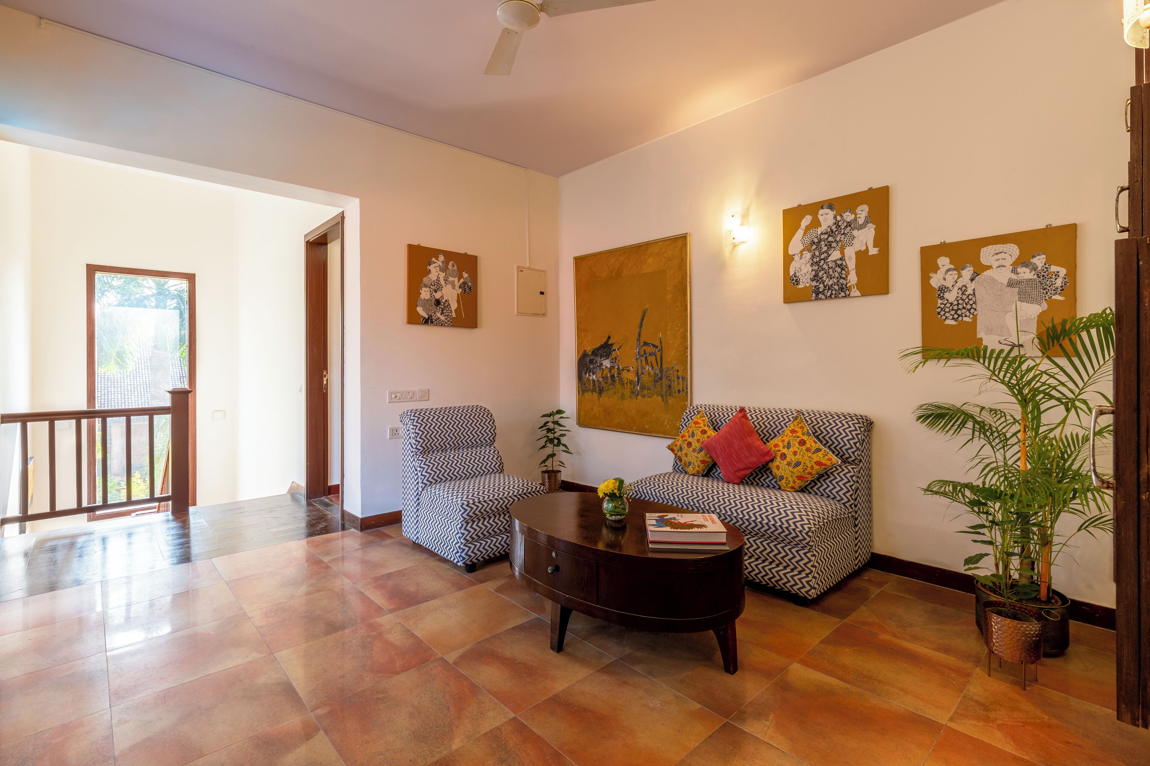 A living room with patterned sofas, a coffee table, and artwork on the walls.