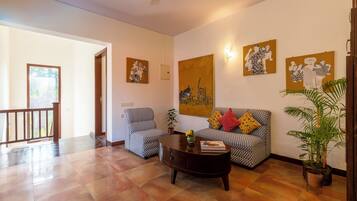 A living room with patterned sofas, a coffee table, and artwork on the walls.