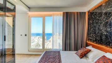 Ein Hotelzimmer mit Bett, einem großen Fenster mit Blick auf die Stadt und einer Marmorwand.