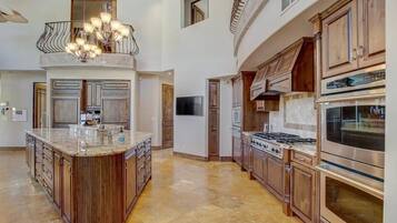 A spacious kitchen with a large island, stainless steel appliances, and wooden cabinetry.