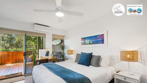 Une chambre à coucher avec un lit, une table de chevet, une lampe et une vue sur l’extérieur.