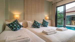 A hotel room with two beds, each with a pillow and a folded towel. There is a window with a view of a swimming pool and outdoor furniture. - Love ao nang pool villa  (อ่าวนาง)