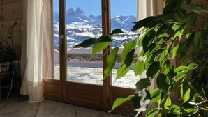Una habitación con un amplio ventanal corredero que da a vistas de la montaña.