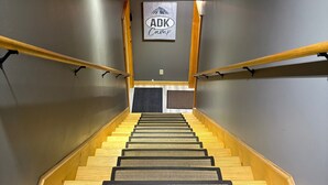 A staircase with wooden handrails and a sign reading "ADK Camp".