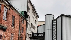 En bygning med et skilt, der viser 'aparthotel forenom', der angiver et lejlighedshotel.