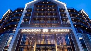 Ein mehrstöckiges Hotel mit markantem Eingangsbereich und Balkonen auf jeder Etage, vor dem Hintergrund ein klarer Himmel.